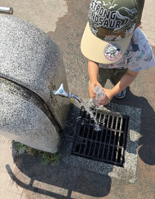 公園の砂場で水遊び